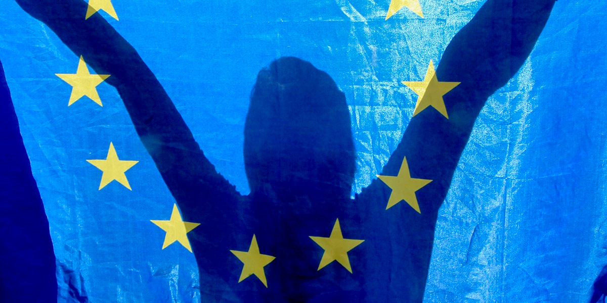 En person håller upp en EU-flagga.