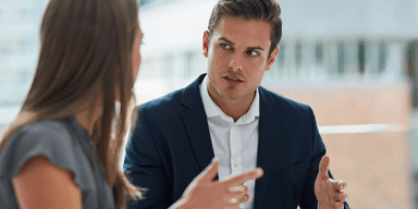 Två kollegor i samtal på kontor, illustration av psykologisk trygghet och öppen dialog.