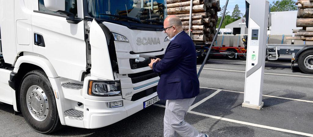 Näringsminister Karl-Petter Thorwaldsson laddar en e-lastbil under sitt besök hos Scania tidigare i sommar. Foto: Chris Anderson