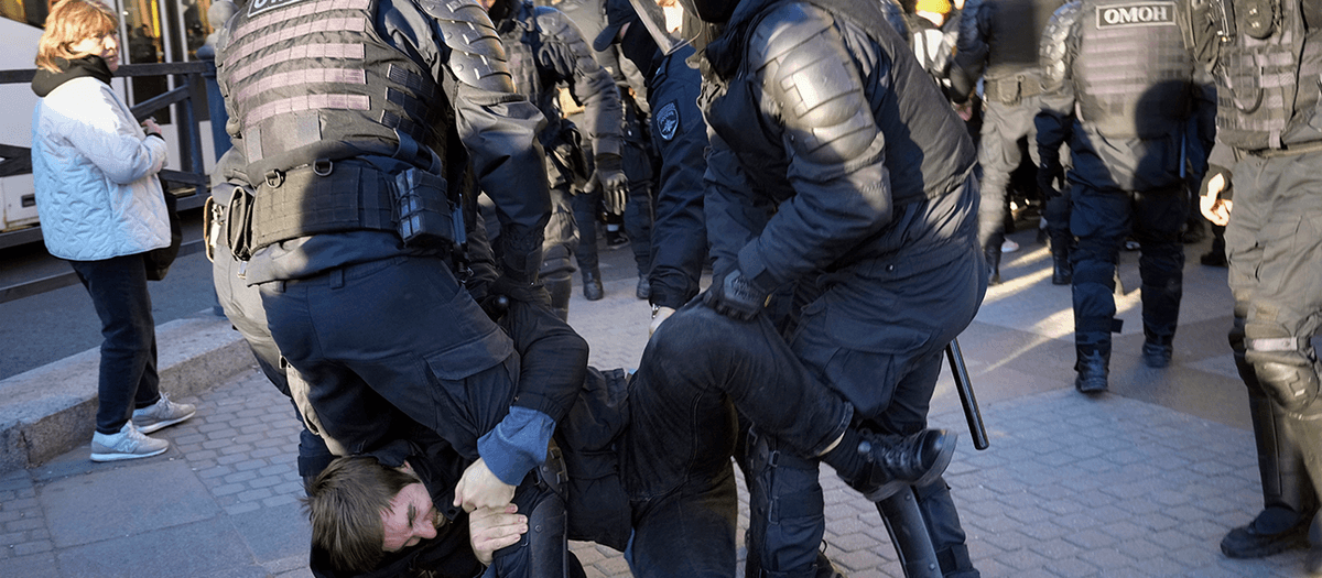 Ryska poliser kvarhåller en demonstrant i St Petersburg som protesterar mot mobilisering under lördagen. Foto: TT