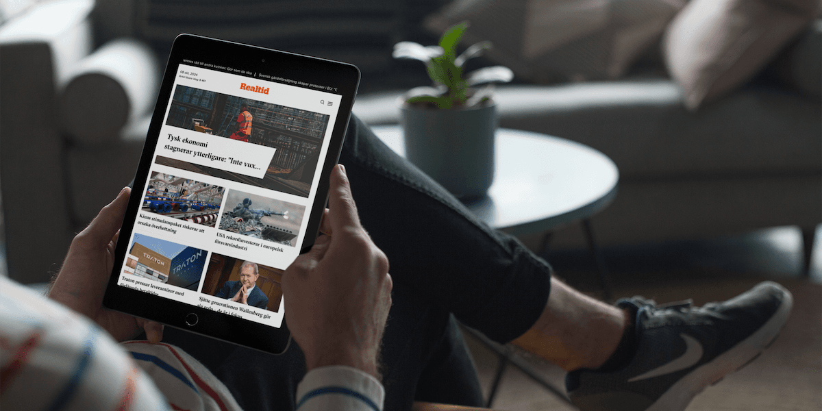 Bild på person som läser nyheter fråm Realtid på sin padda.