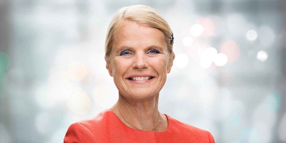 Ewa Glennow i orange tröja mot suddig bakgrund